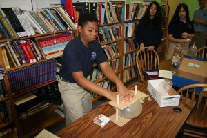Pierre Lesperance, 12, presses a balloon down on a bed of nails and explains why it doesn't immediately pop.